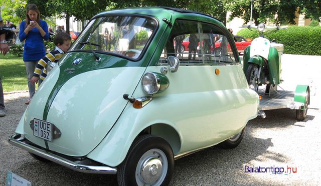 Ez is BMW, egy első ajtós Isetta 300-as, amit olasz licensz alapján 1957-ben gyártottak. A kocsi egyhengeres, négyütemű, 298 köbcentiméteres motorja 13 lóerős. Amit azért nem kevés, ha arra gondolunk, hogy a kiállításra még utánfutót is vontatott a magyar ipar egyik fontos darabjával, egy 58 kilogrammos Panni robogóval.