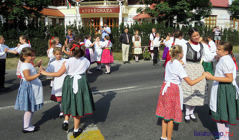 Az iskolások tánca a községháza előtt - középen a polgármester